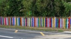 Забор в виде цветных карандашей создается из бревен или даже досок, которые обрезаются сверху по виду заточки и просто окрашиваются в разные цвета